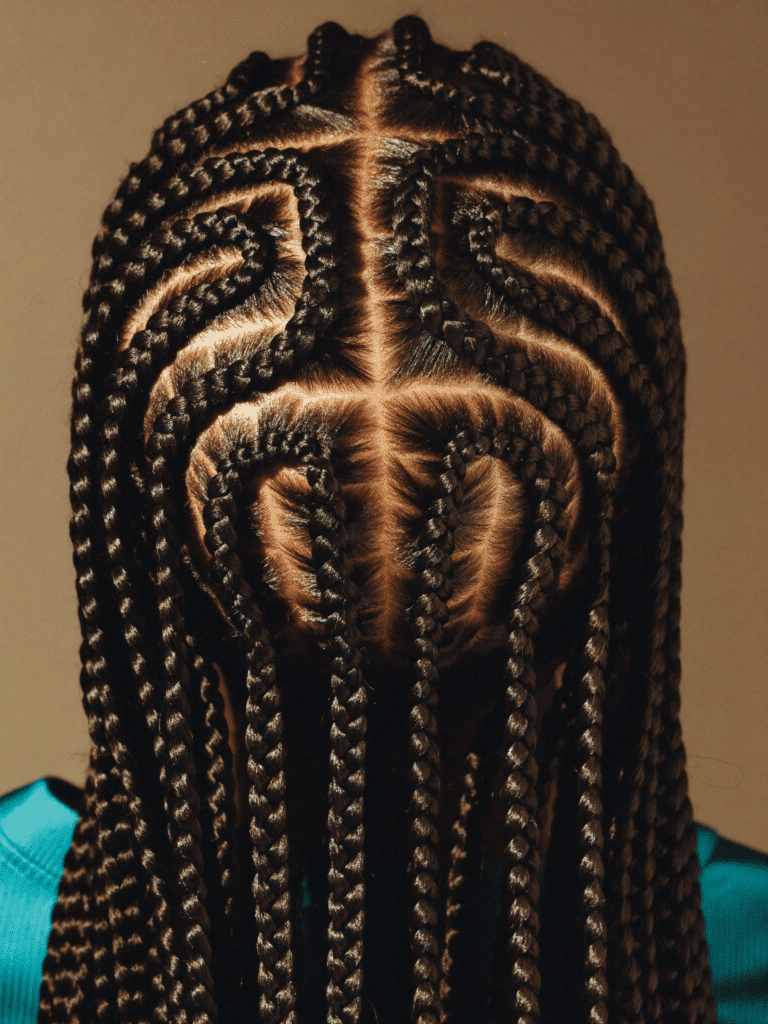 Back view of intricate feed-in cornrows in a geometric pattern ending in long braids.