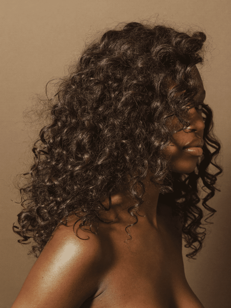 Voluminous defined wash-and-go curls with high shine, photographed three-quarter on.