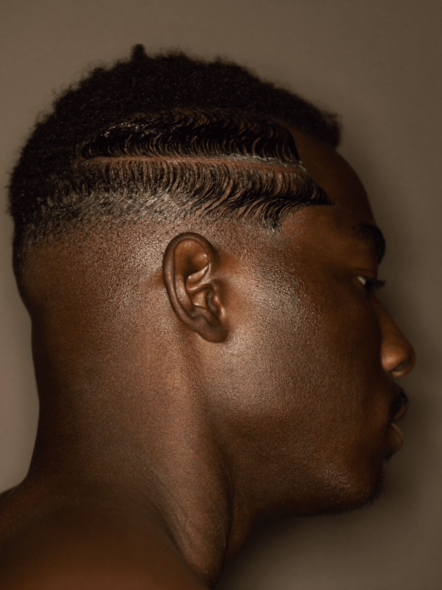 A crisp skin fade with a sharp line-up and defined waves, photographed in profile.